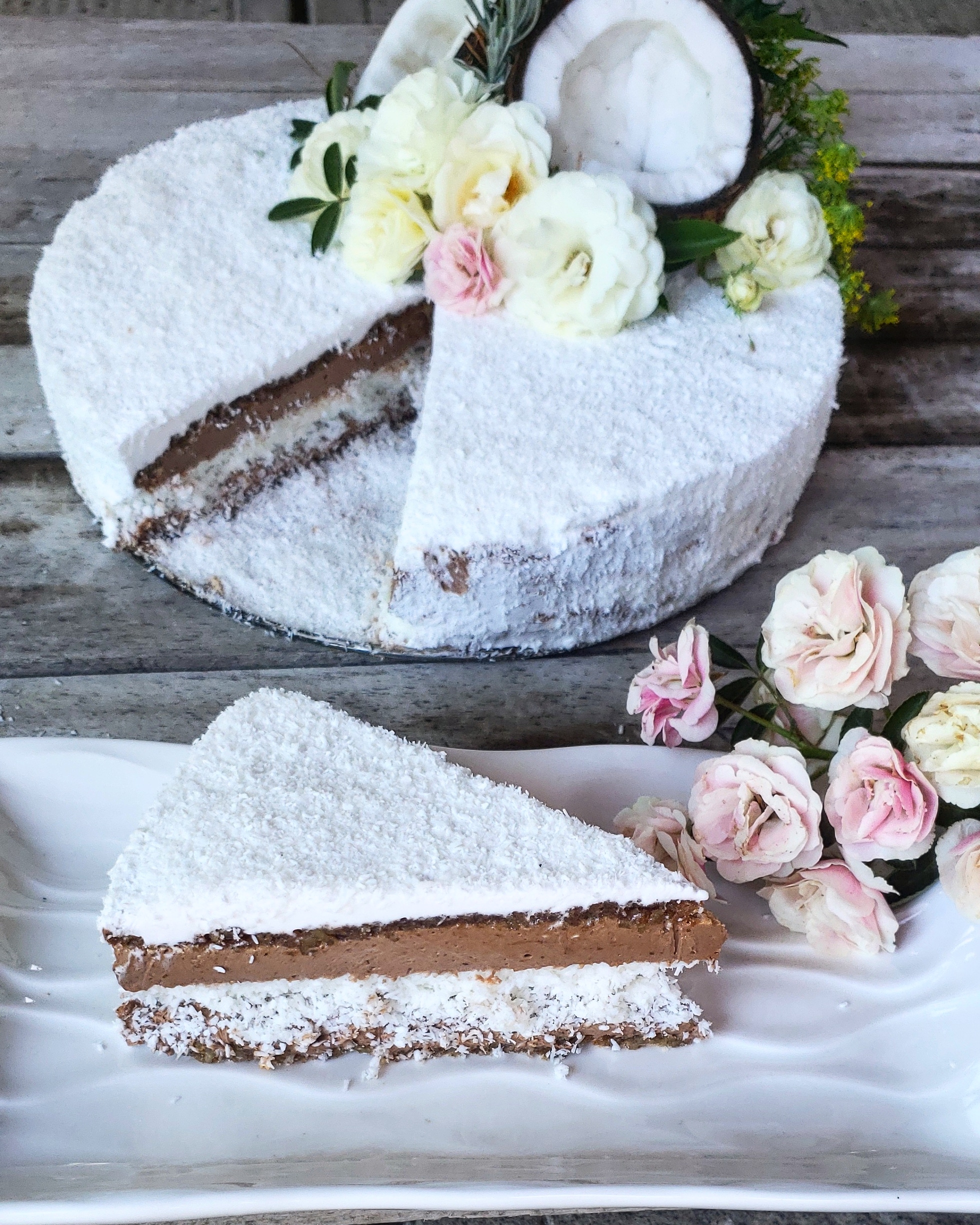 Coconut cake and a piece of coconut cake on a plate