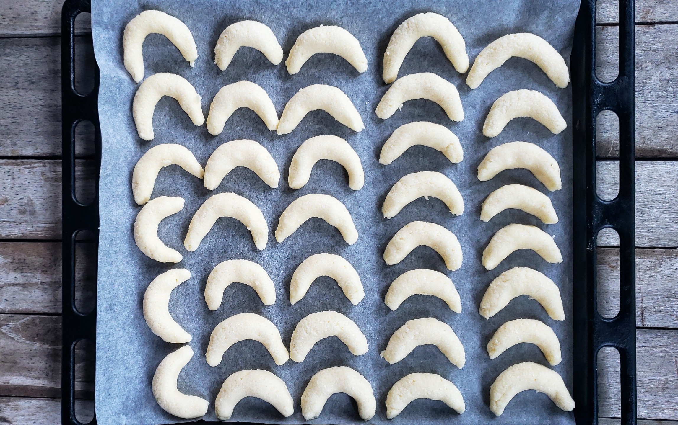 Moon shaped cookies lying on a baking sheet