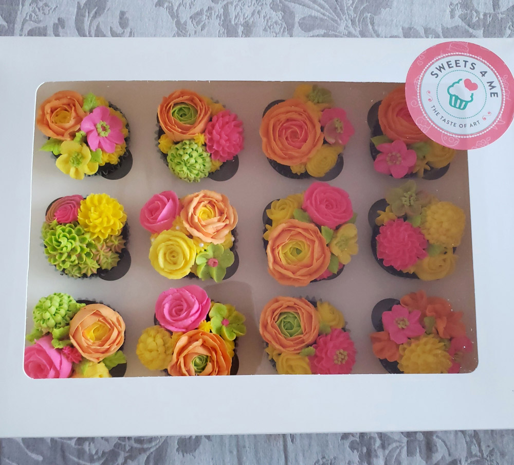 12 cupcakes in a cupcake box, decorated with buttercream flowers